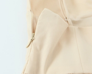 Close-up of invisible zipper and seam detail on beige poplin midi dress fabric
