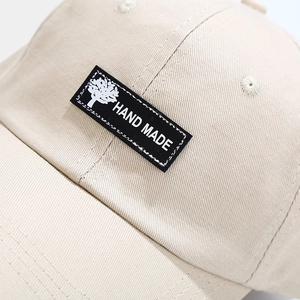 Detailed macro view of the hand-made label and twill fabric texture on a beige baseball cap