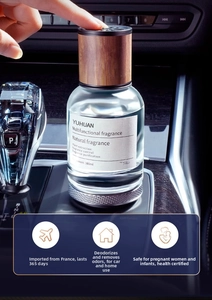 Detail of 160ml glass car diffuser with walnut wood lid on a luxury vehicle console