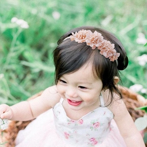 Detail of pink floral baby headband with four soft chiffon flowers on a toddler girl