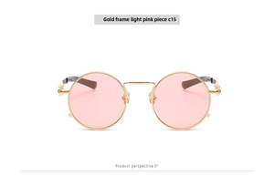 Detail of retro steampunk sunglasses with gold metal frame and light pink round lenses