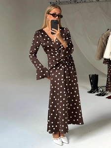 Détail du col en V et de la taille froncée sur une robe longue marron à pois blancs