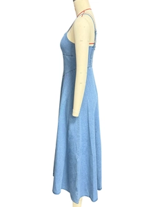Dettaglio dell'abito lungo in denim blu che mostra il taglio slim e l'orlo ampio
