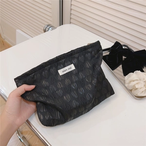 Detail of black heart jacquard fabric and simple wish label on soft canvas pouch
