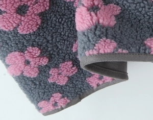 Detailed macro view of gray fleece vest with pink floral print and premium stitching