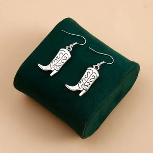 Détails des boucles d'oreilles bottes de cowboy argentées avec motifs vintage finement gravés