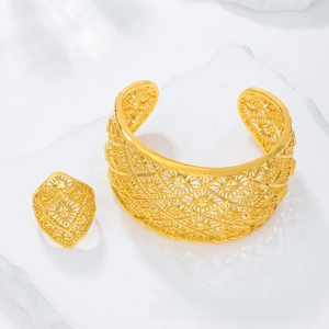 Detailed view of golden filigree hollowed-out cuff bracelet and matching ring set