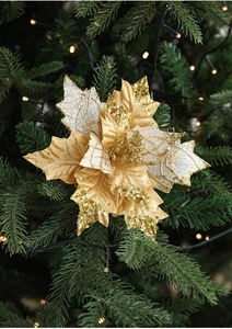 Close-up of artificial gold poinsettia flower with sequins on a decorated Christmas tree