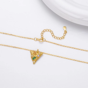 Macro detail of gold S925 sterling silver necklace with colorful zircon triangle pendant