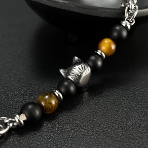 Macro shot of stainless steel wolf head bead with tiger eye and black stone beads