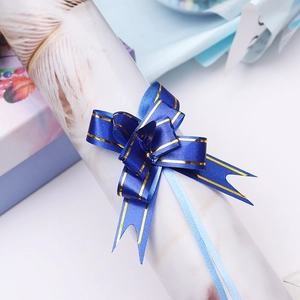 Macro view of a royal blue pull bow ribbon with gold edges for gift box decoration
