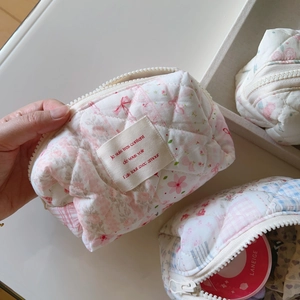 Vue détaillée de la trousse de maquillage matelassée à motifs floraux et fermeture éclair