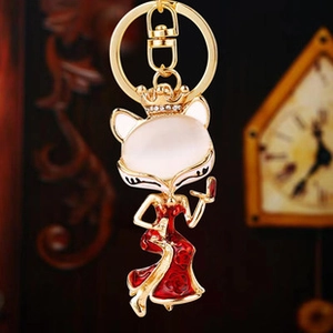 Macro view of crystal fox head keychain with opal stone and red enamel gown detail