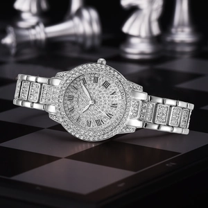 Close-up of a silver rhinestone ladies watch with Roman numerals on a chess background