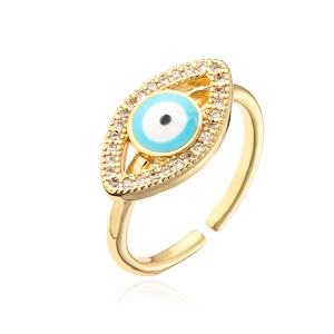 Macro detail of gold evil eye ring with blue enamel and pave-set zircon stones