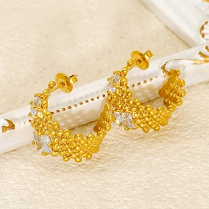 Macro view of gold-plated U-shaped earrings with textured finish and square zircons
