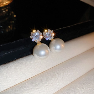 Macro shot of pearl stud earring with sparkling zircon on premium gold plated base