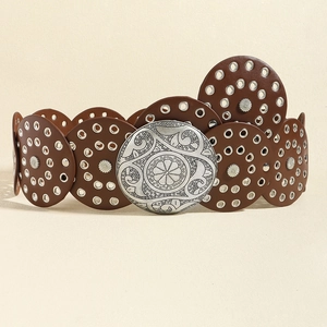 Detail of a brown leather belt with silver metal eyelets and an engraved floral buckle