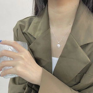 925 sterling silver evil eye pendant necklace worn by model in elegant suit style