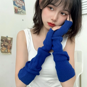 Detail of royal blue ribbed knit arm sleeves with fingerless design on a model