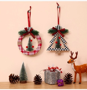 Close-up of rustic Christmas wreaths with plaid bows and cedar trees hanging decor