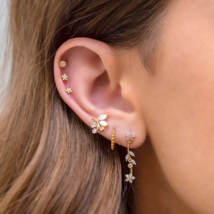 Close-up of gold star and moon tassel earring set with inlaid zircons on ear