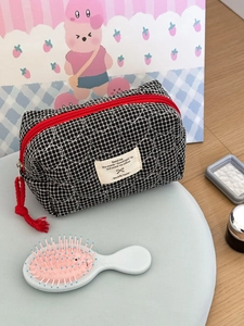 Borsa trapuntata a scacchi bianchi e neri con motivo a cuore e cerniera con nappa rossa