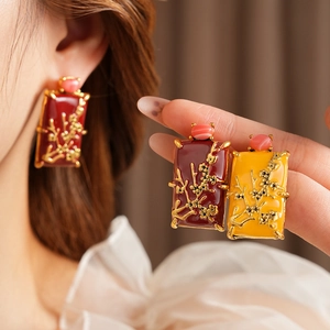 Détail de boucles d'oreilles vintage en émail avec motif fleur de prunier et perles