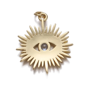 Macro detail of gold sun-shaped evil eye pendant with blue zircon stone inlay