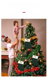 Famille tenant un enfant près du sapin avec chaussettes de Noël tricotées vertes