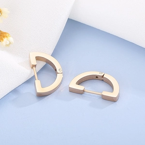Macro detail of rose gold D-shaped stainless steel earrings with polished metal finish