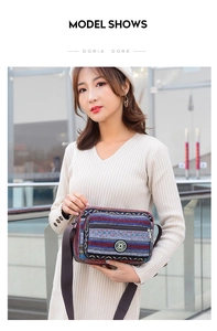 Ethnic striped canvas crossbody bag with adjustable strap worn by a model
