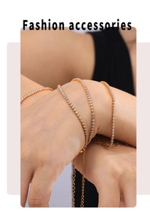 Close-up of gold chain bracelet with white cubic zirconia worn on wrist in fashion layers
