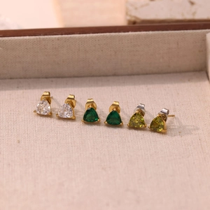 Three pairs of elegant triangle-cut gemstone stud earrings in clear, emerald, and olive green