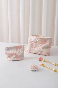 Detail of two-piece floral jacquard makeup bags in soft pink and purple tones