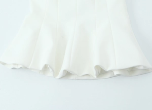 Detail of white tube top with flared hem showing fabric texture and sewing craftsmanship