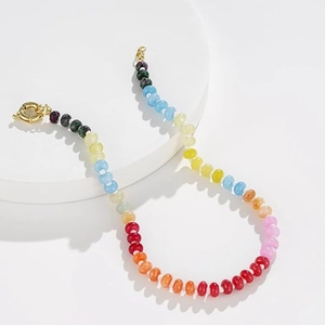 Detail of colorful bohemian stone bead necklace featuring a gold round spring clasp