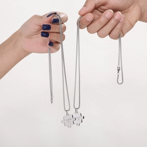 Stainless steel puzzle piece couple necklaces with Weirdo engraving on white background