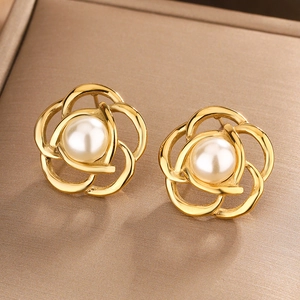 Macro shot of camellia pearl earrings with gold hollowed petals in vintage French style