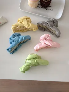 Close-up of five pleated fabric hair claws in pastel colors for sweet hair styling