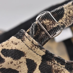 Detailed view of large leopard print cotton fabric and silver metal adjustable buckle