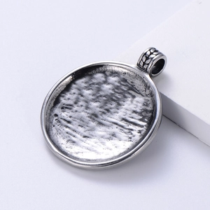 Macro view of silver steel medallion with hammered texture and vintage finish