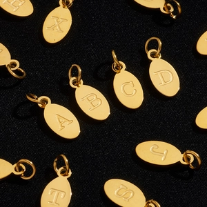 Macro shot of assorted golden oval letter charms on textured black background