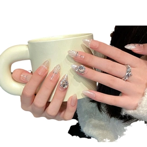 Handmade long almond press-on nails in nude pink with silver glitter and 3D rhinestones