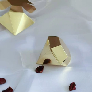 Elegant gold diamond shaped wedding favor box on white silk with dried petals