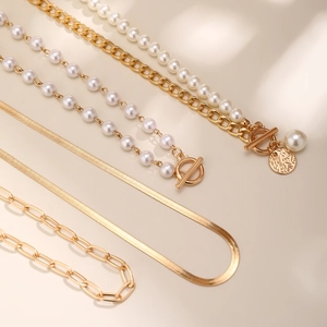 Close-up of layered baroque pearl necklace with gold toggle clasp and metal pendant