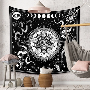 Detail of bohemian tapestry featuring occult symbols like pentagrams and moon phases