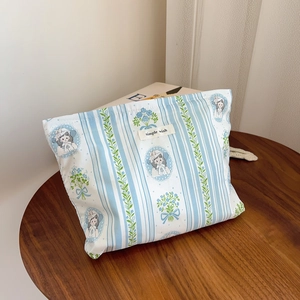 Detail of floral stripe cotton makeup bag with vintage illustration and woven label