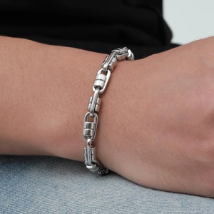 Detail of silver stainless steel bullet link chain bracelet on a male model wrist