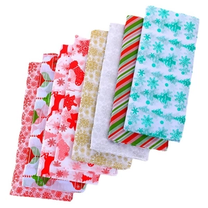 Eight rolls of Christmas wrapping paper with festive patterns like reindeer and trees